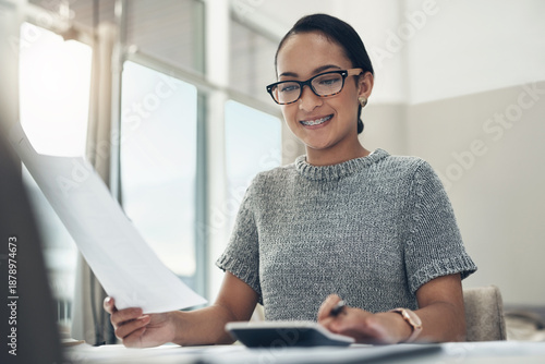 Home budget, finances and bills being calculated by a young woman sitting at home. Young female calculating her expenses, debt and spendings while doing monthly tax returns or planning in the lounge