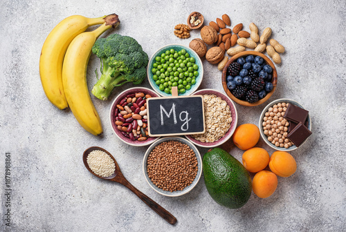 Assortment of magnesium rich food products with Mg sign on grey stone background representing healthy nutrition