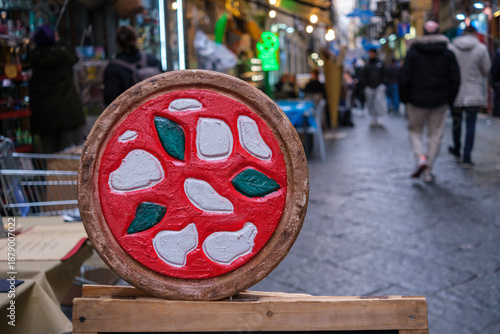In the historic center of Naples, a drawing of a pizza on wood