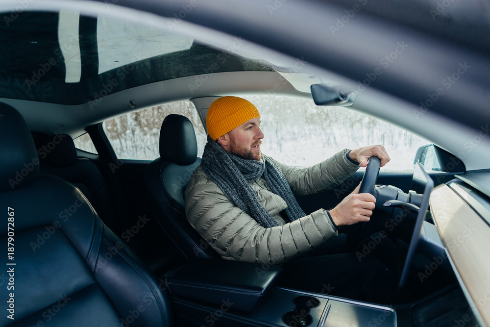 Naklejka premium Male driver operating electric car in winter