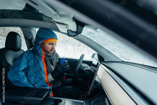 Фотография Electric car driver battling cold winter weather