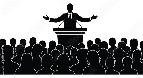 A formal speaker addresses a large crowd of people from a podium captured in a striking black and white silhouette