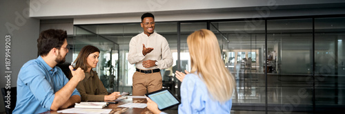 Fotografie Young happy African American male executive company leader discussing project management planning strategy working with diverse busy colleagues company team at office corporate board group meeting