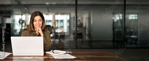 Happy busy mature business woman entrepreneur in office using laptop at work, smiling professional middle aged female company executive manager working looking at computer at workplace.