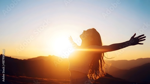 Woman embracing freedom with arms outstretched at sunset