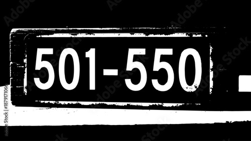 Close-up street address plate reading 501-550 on a building facade with bold typography and urban texture.