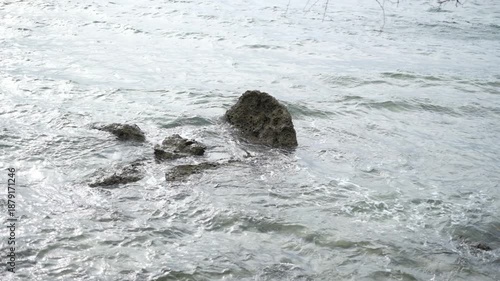 Peaceful ocean water surrounding scattered coastal rocks in shallow sea