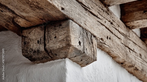 Close up detail of heavy wooden beams and joints in a white wall structure highlighting rustic architecture and natural textures.