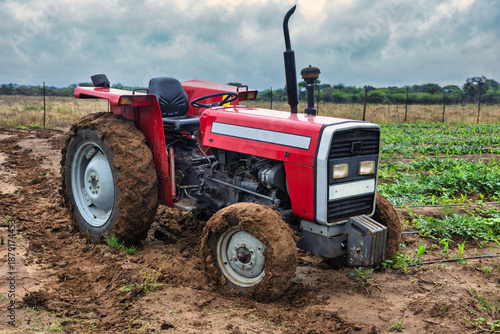 agricultural tractor in deep mud on a farm field, agricultural work in challenging, wet conditions, drip irrigation system