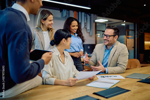 Group of diverse business people engaging in a lively discussion during a team meeting in a modern office boardroom