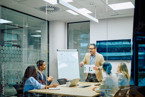 Obraz na plátne Business leader presenting financial data to diverse team members during a corpo