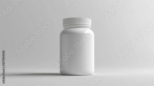 A white empty pill bottle with a cap sitting on a grey surface.