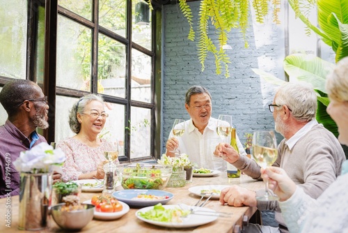 Εκτύπωση καμβά A diverse group of elderly friends, including men and women, enjoying a meal together