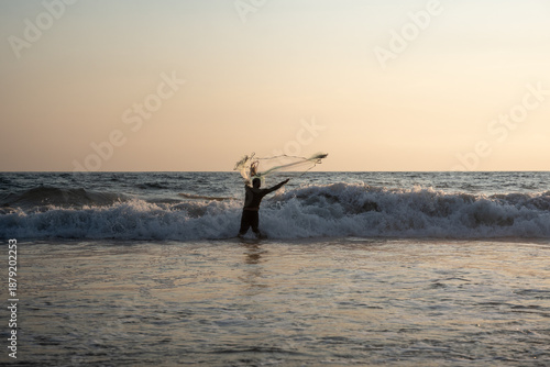 Bild auf Leinwand Fisherman throwing a cast net or atarraya at the seashore with water at his waist