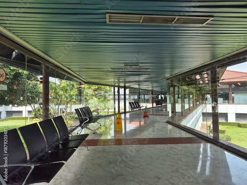 Modern airport corridor connecting terminal and waiting area with spacious and comfortable interior design.