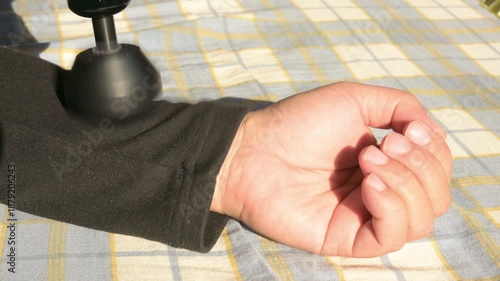 a massage gun rapidly tapping the arm video with sound
