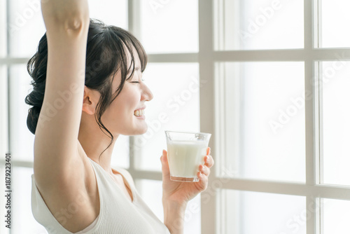 Fotografija Asian woman drinking milk in the morning at home