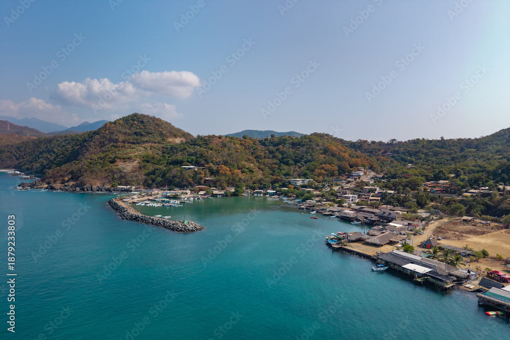 Fototapeta premium defaultAerial view of the beach and small port of Puerto Vicente Guerrero. Fishing boats in the Costa Grande bay. Tecpan de Galeana, Guerrero, Mexico. costa grande
