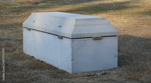 Φωτογραφία Concrete burial vault or grave liner in a green cemetery field for funeral servi