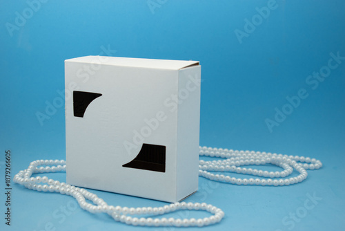 Minimal cosmetic packaging mockup with white boxes and luxury pearls on pastel background