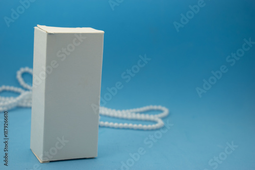 Minimal cosmetic packaging mockup with white boxes and luxury pearls on pastel background