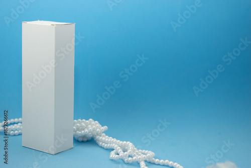 Minimal cosmetic packaging mockup with white boxes and luxury pearls on pastel background