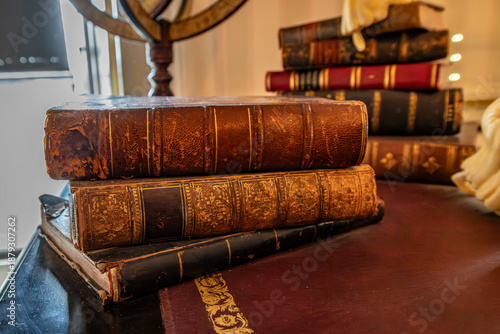 Bilde på lerret Stack of vintage leather bound books on an antique wooden desk