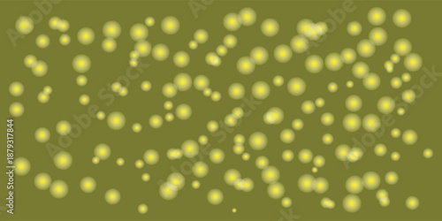 Glowing yellow circular bokeh lights on a dark green background creating a magical abstract pattern