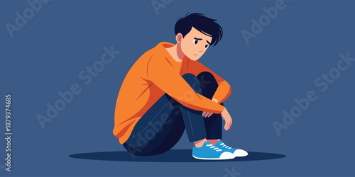 A young man in his late teens or early twenties with a concerned expression, sitting alone on a blue background, conveying a sense of sadness or worry.