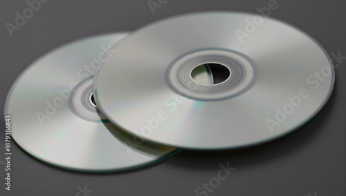 CD-ROM Disks: A pair of sleek, silver CD-ROM disks, a symbol of digital data storage and multimedia entertainment, rest against a neutral-toned backdrop.