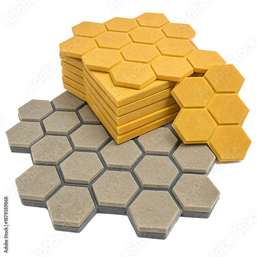 Acoustic honeycomb tiles for soundproofing and interior design. Stack of yellow and gray hexagonal panels for noise reduction and decoration.