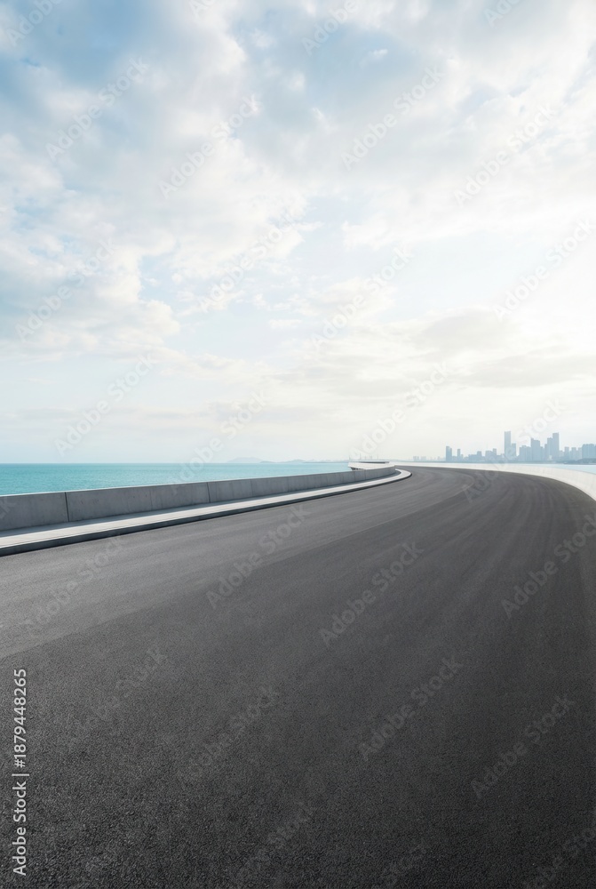 Fototapeta premium Empty coastal highway with panoramic ocean views and a cloudy sky.