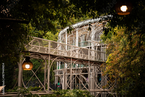 Foto Elevated Walkway and Steel Framework of Ópera de Arame Surrounded by Forest - Cu