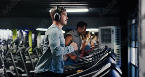Fitness, running or man with headphones on treadmill in gym, streaming music or cardio workout for health. Performance, exercise machine or athlete with audio tech to listen, training album or active