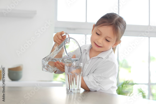 Cute little girl pouring wa...