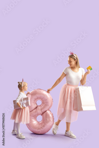 Little girl with her mother, shopping bags and balloon in shape of figure 8 on lilac background. International Women's Day