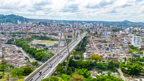 Aerial view of Pereira bridge in Risaralda, Colombia, showcasing city skyline and lush greenery.