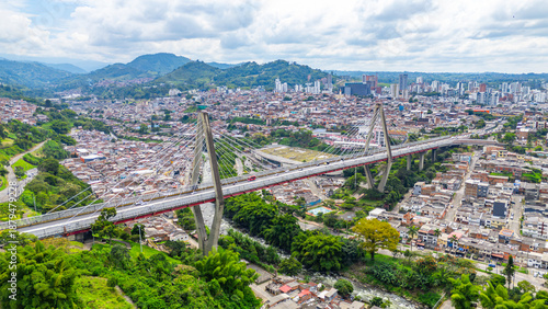 Stunning aerial view of Pereira Bridge connecting urban areas of Pereira, Risaralda, surrounded by lush green hills in Colombia.