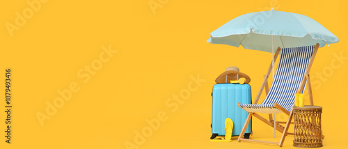 Photos Striped deck chair with umbrella, suitcase and sunscreen cream on yellow backgro