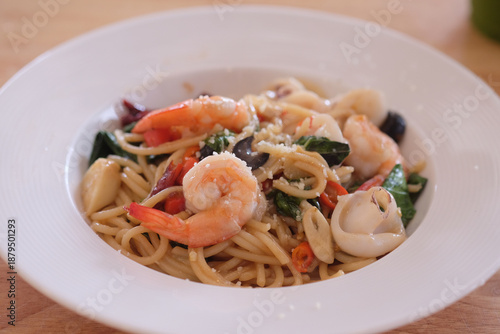 Spaghetti with shrimp and basil on wooden table, italian food