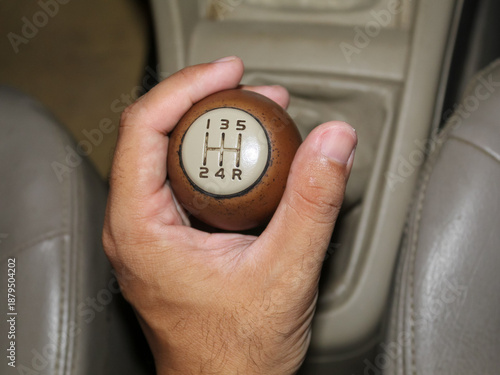 Hand holding manual car gear shifter