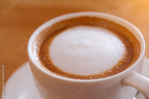 Cappuccino coffee in white cup on wooden table, stock photo