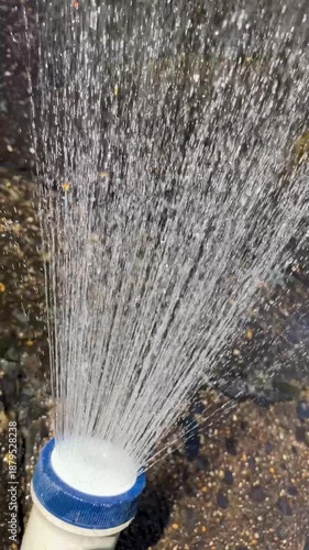 Splashing water from an outdoor shower during the day; Vertical; Video