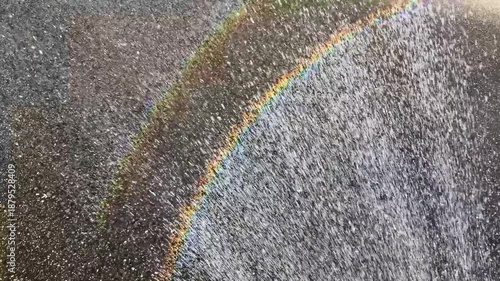 A rainbow over the spray from an outdoor shower during the day; Horizontal; Video