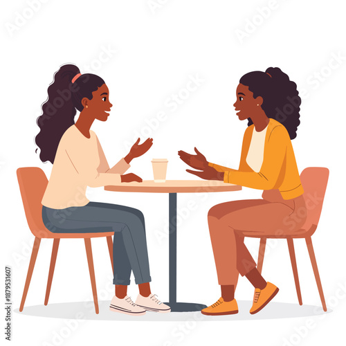 Two women engaged in conversation while seated at a small table in a casual setting