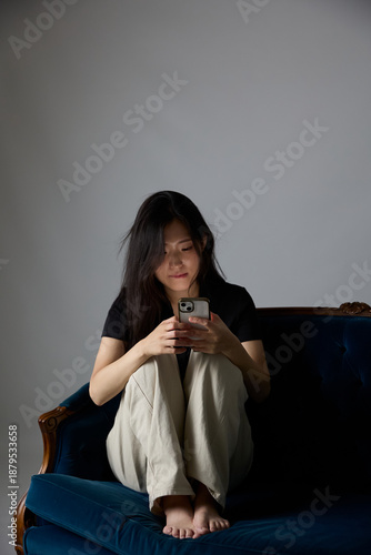 Risk of illegal cyber gambling concept, Korean woman holding smartphone in the dark