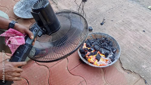 closeup of burning charcoal and benzoin or frankincense in a rustic pan with fan wind