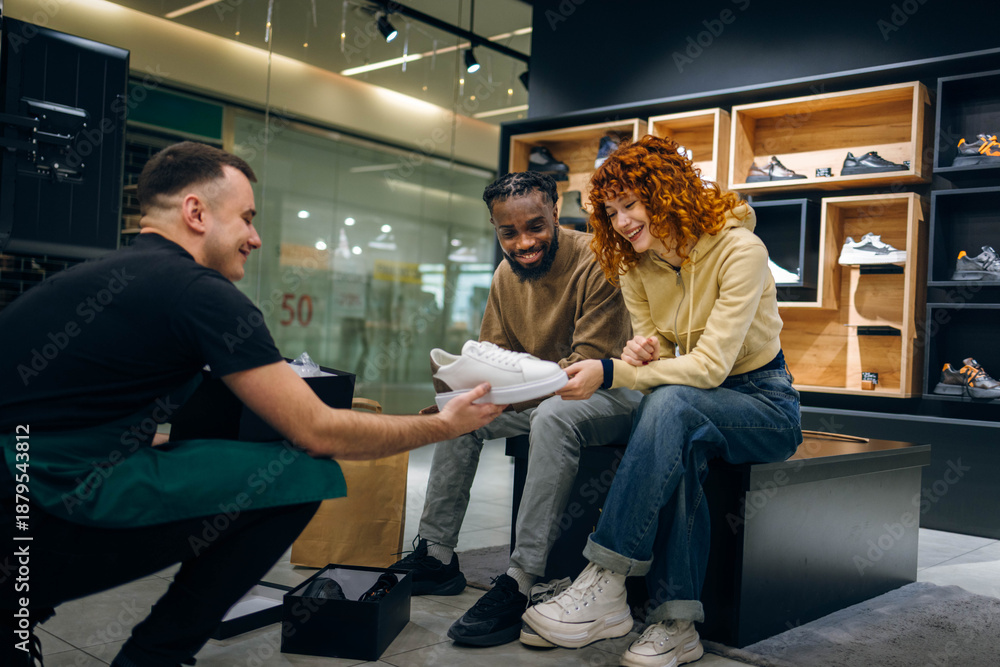 Naklejka premium Couple buying sneakers in a store
