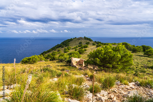 Ruins of an old stone tower on mountain with sea view in Canyamel, Mallorca, Spain. Historic coastal defense remains surrounded by rocky landscape and Mediterranean scenery.