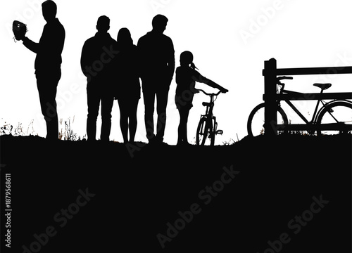 Silhouette of a family with bicycles and a fence in a field at dusk people children